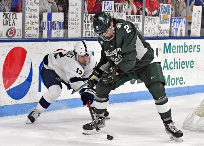 Penn State forward Ben Schoen battles for a puck against the Michigan State Spartans at Pegula Ice Arena in University Park, Pa.