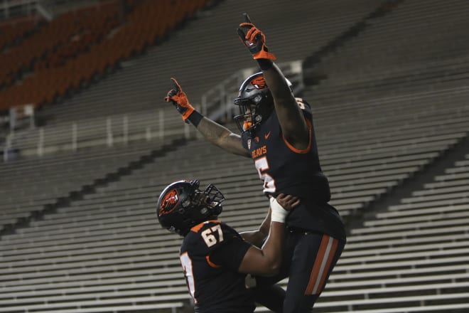 Joshua Gray (67) lifts up running back Jermar Jefferson (6) after scoring against WSU