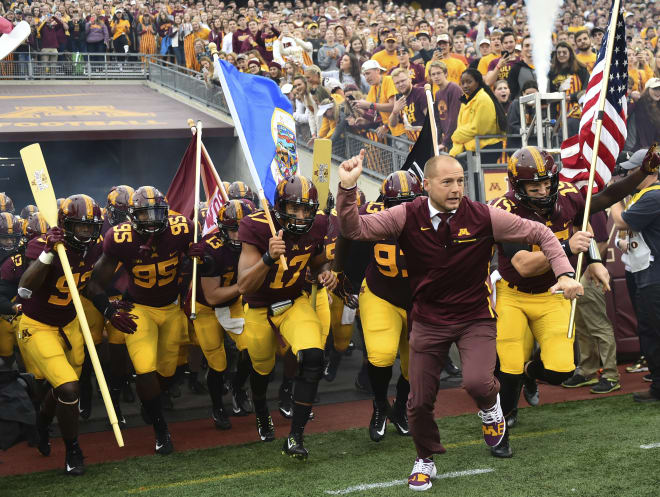 Minnesota coach P.J. Fleck leads his team onto the field for an NCAA college football game against Illinois in Minneapolis.