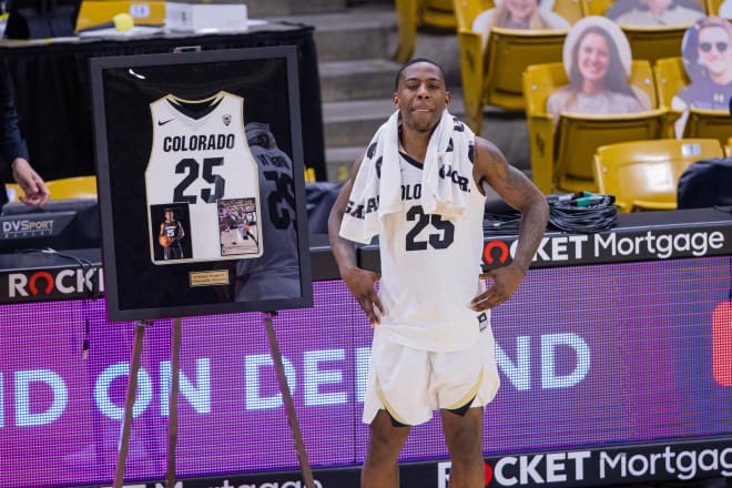 McKinley Wright IV poses with his framed jersey during CU's postgame Senior Night acknowledgements.