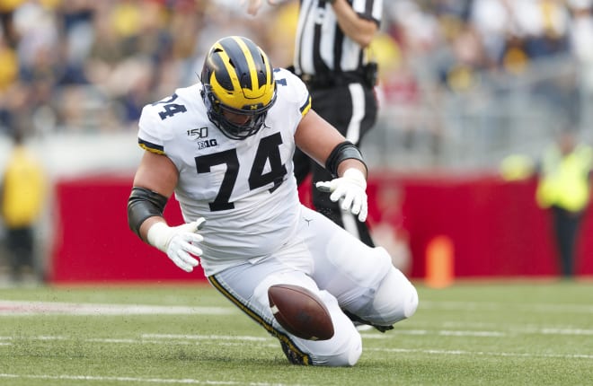 Michigan Wolverines football senior left guard Ben Bredeson recovers a fumble against Wisconsin this year.