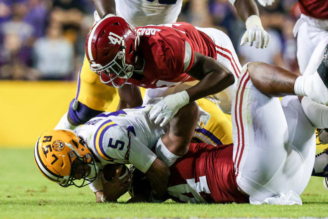 LSU Tigers quarterback Jayden Daniels (5) is tackled by Alabama Crimson Tide defensive lineman DJ Dale (94) and linebacker Chris Braswell (41) during the second half at Tiger Stadium. Photo | Stephen Lew-USA TODAY Sports