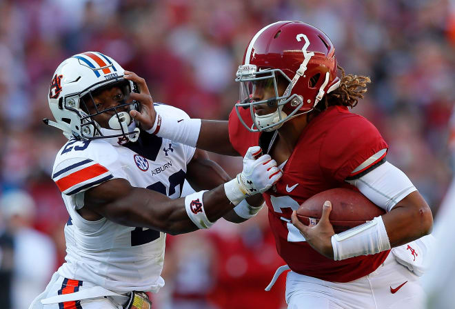 Alabama quarterback Jalen Hurts (2) stiff-arms an Auburn defender during last year's game. Photo | Getty Images