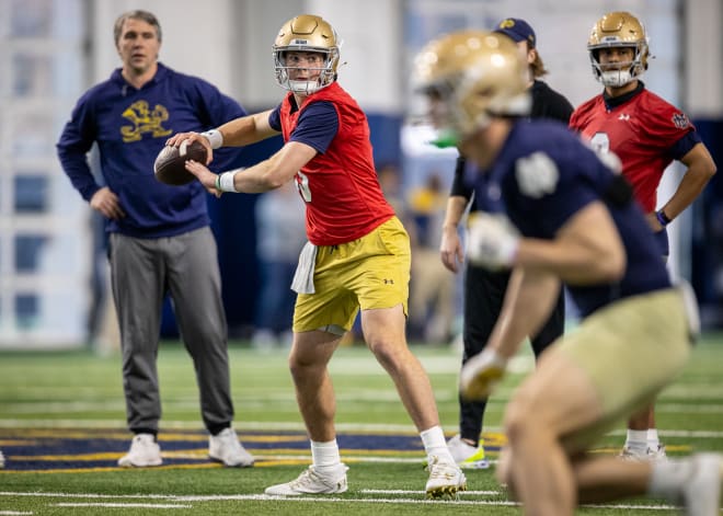 Irish QBs coach Gino Guidugli (left) looks on as Duke transfer QB Riley Leonard throws a pass during Notre Dame football spring practice on Thursday.