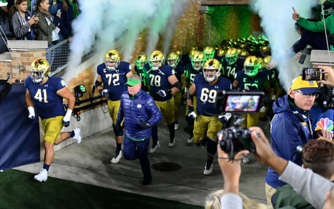 Notre Dame football head coach Brian Kelly leading the team onto the field