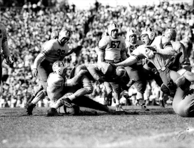 Buist Warren of Tennessee is thrown for five-yard loss by Hugh McCullough, an Oklahoma back, in the second period of the Orange Bowl at Miami on Jan. 2, 1939. Bob Seymour, (36) left, grins as Merle Williams (28), drives in to clinch the tackle during game in Miami, Fla. (AP Photo)