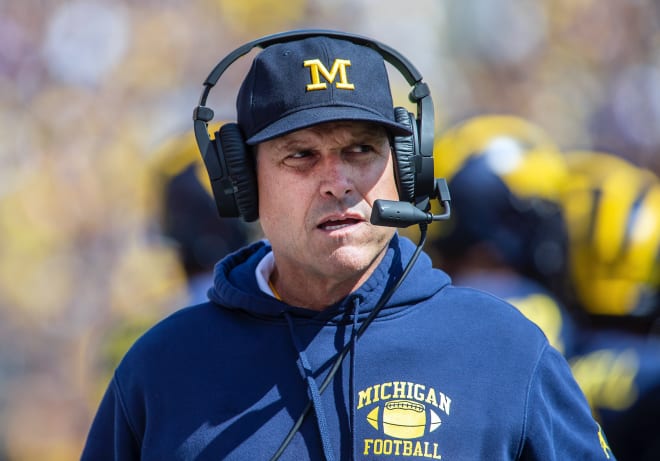 Michigan football head coach Jim Harbaugh and his team are 19-point favorites at Illinois Saturday.