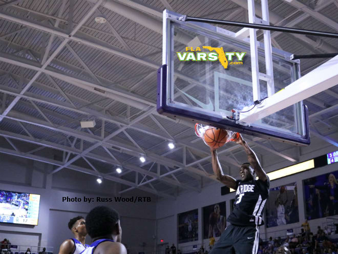 Oak Ridge power forward Emmitt Williams finishes a dunk while John Marshall's Isaiah Todd (left) and a teammate look on