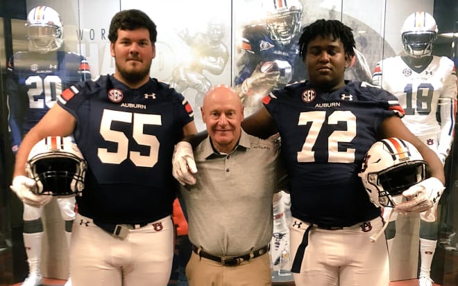Pensacola (Fla.) offensive linemen Hunter Rayburn and Adrian Medley pose for a picture Saturday with Auburn offensive line coach J.B. Grimes.