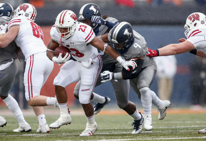onathan Taylor #23 of the Wisconsin Badgers runs the ball as Dele Harding #9 of the Illinois Fighting Illini tries to make the tackle from behind at Memorial Stadium on October 28, 2017 in Champaign, Illinois.