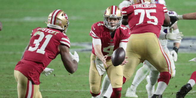 San Francisco 49ers quarterback Nick Mullens (4) pitches the ball to running back Raheem Mostert (31) against the Buffalo Bills during the third quarter at State Farm Stadium. 