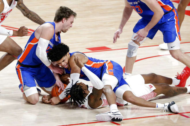 Boise State guard Max Rice, left, and guard RayJ Dennis, center, battle for the loose ball over Houston forward J'Wan Roberts, bottom, during the first half of an NCAA college basketball game Friday, Nov. 27, 2020, in Houston. (AP Photo/Michael Wyke)