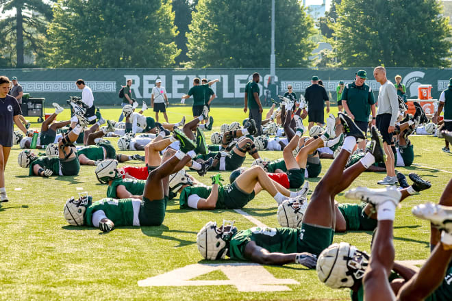 Michigan State football players stretch during the opening practice of 2023 fall camp. 
