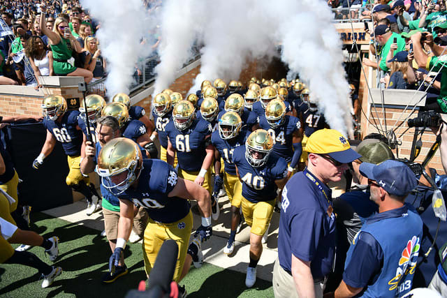 Fighting Irish football players emerging from the tunnel at Notre Dame Stadium