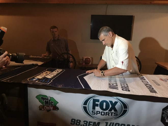 Frank Martin signs a banner from Bon Secours Arena where the Gamecocks won their first two NCAA Tournament games