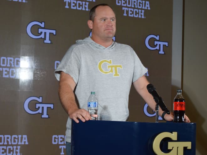 Key in his standard coaching gear, an inexpensive hoodie, sleeves cut off contrasts Collins who wore GC5 monogramed sweatshirts for media sessions
