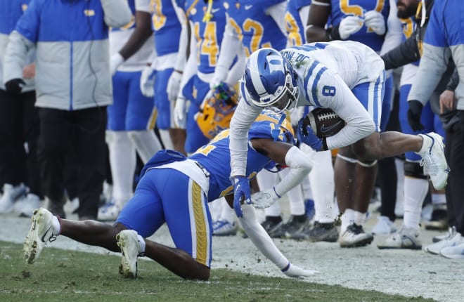 Duke's Jordan Moore, right, is tackled by M.J. Devonshire during last season's matchup. 