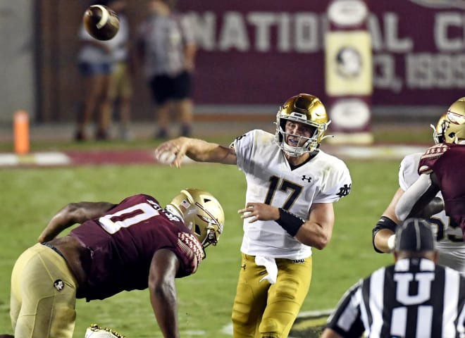 Jack Coan (17) unloads the ball under pressure during his first start for Notre Dame, a 41-38 OT victory last season at Florida State.
