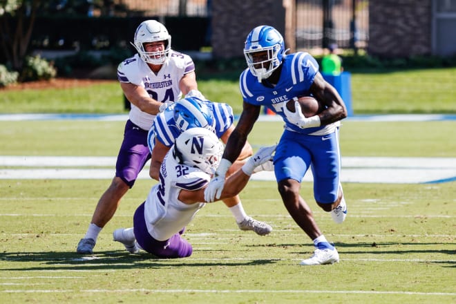 Duke running back Jordan Waters, right, runs through a tackle attempt by Northwestern's Bryce Gallagher on Saturday. 