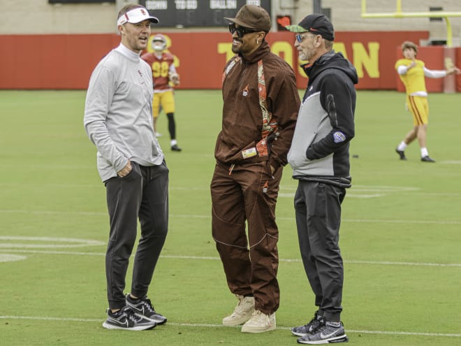 Lincoln Riley talks with his former QB Jalen Hurts and USC director of football operations Clarke Stroud at practice Thursday.