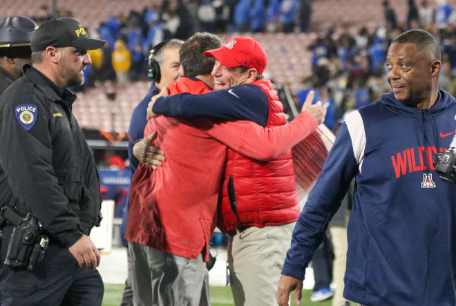 Arizona athletic director Dave Heeke (right) and head coach Jedd Fisch embrace after the Wildcats' upset win over UCLA at the Rose Bowl in November.
