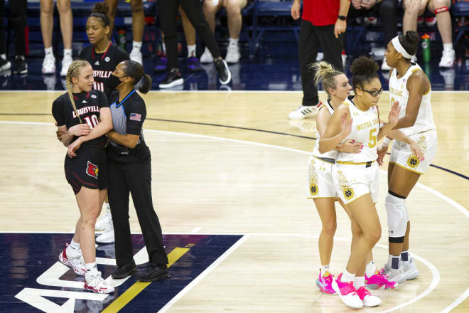 An official holds Louisville's Hailey Van Lith (10) while Notre Dame's Dara Mabrey holds teammate Olivia Miles (5), next to Maya Dodson after an altercation in Louisville 86-64 rout of the Irish.
