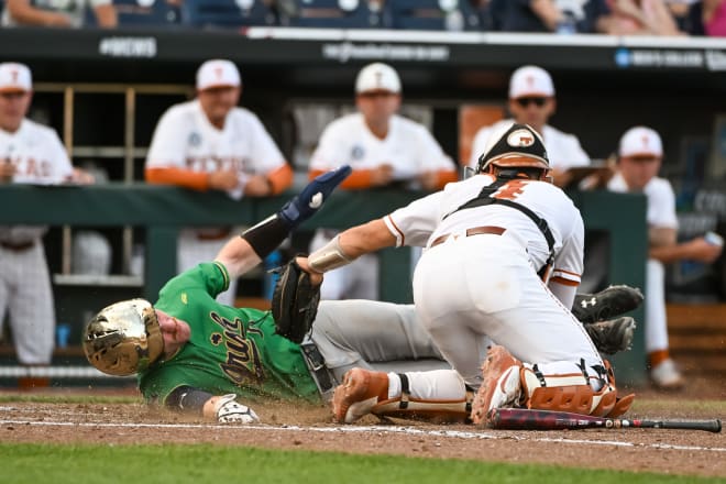 Notre Dame's Jack Brannigan scores a run in the College World Series Friday night ahead of the tag of Texas catcher Silas Ardoin. Brannigan was initally called out, but replay reversed the outcome.