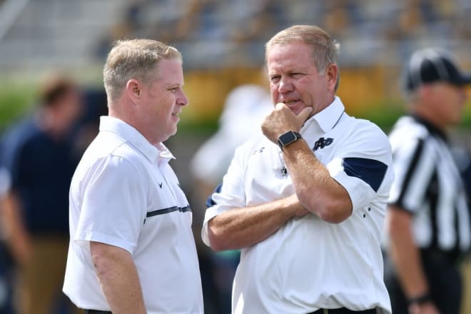 Notre Dame head coach Brian Kelly talking to special teams and recruiting coordinator Brian Polian.