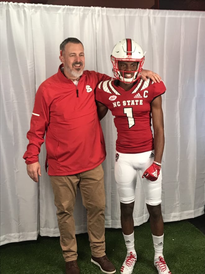 White is shown here with Wolfpack defensive line coach Kevin Patrick, who recruited him to NC State.