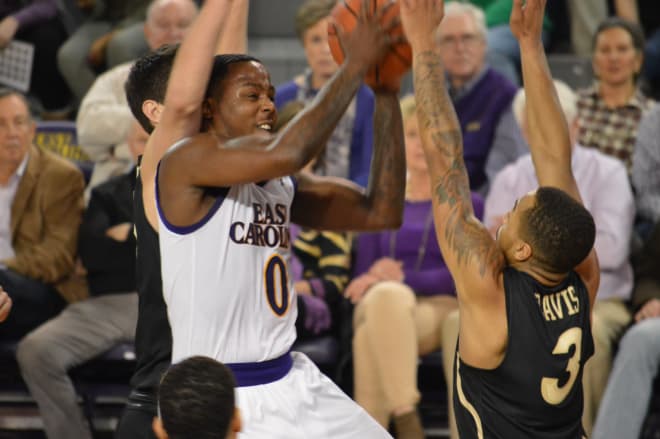ECU guard Isaac Fleming drives past Charlotte's Milos Supica and over Jon Davis in Monday night's loss.