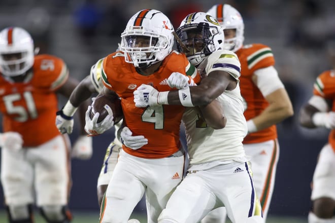 Miami Hurricanes running back Jaylan Knighton (4) is tackled by Georgia Tech Yellow Jackets defensive back Zamari Walton (7) in the second half at Bobby Dodd Stadium. Mandatory Credit: Brett Davis-USA TODAY Sports