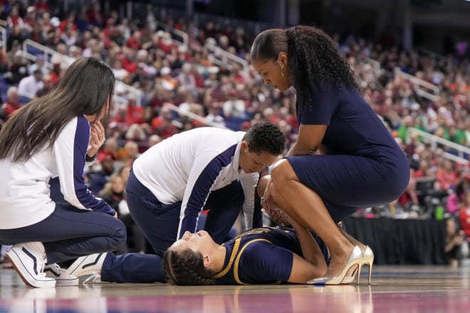 Notre Dame trainer Anne Marquez works on the left knee of Irish forward Kylee Watson as head coach Niele Ivey looks on during ND's 82-53 ACC Tourney semifinal romp over Virginia Tech on Saturday.