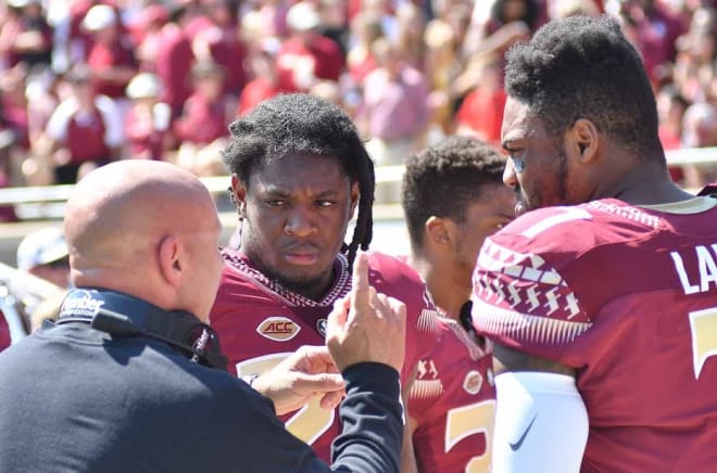 FSU defensive coordinator Charles Kelly talks to safeties Trey Marshall and Ermon Lane. The defense got off to a slow start and faltered at key moments again Saturday.