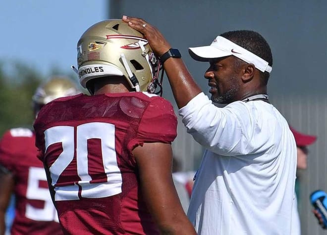 FSU coach Willie Taggart shares a few words with freshman linebacker/safety Jaiden Woodbey.