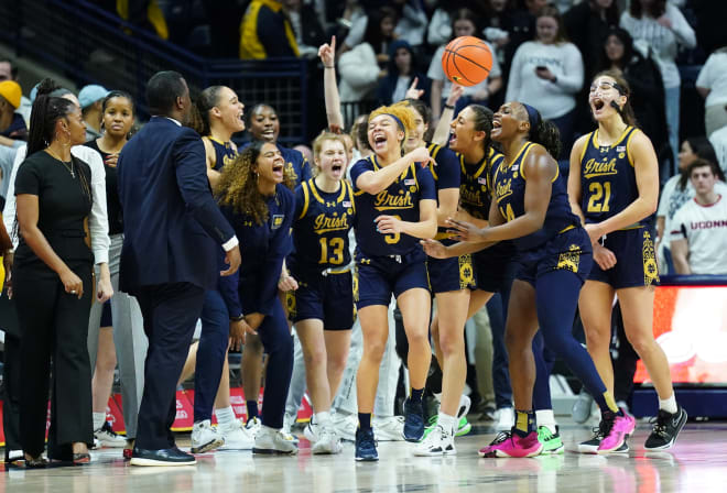 Freshman Hannah Hidalgo (3) and No. 15 Notre Dame celebrate an 82-67 takedown of UConn, Saturday nightin Storrs, Conn.