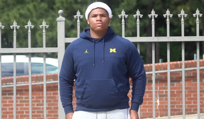 Five-star defensive tackle Walter Nolen holds a Michigan Wolverines football recruiting, Jim Harbaugh.