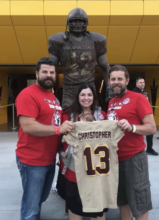 Caleb Christopher's siblings pose with the commemorative jersey they were given in his honor, in front of the Pat Tillman statue in the north end zone of Sun Devil Stadium