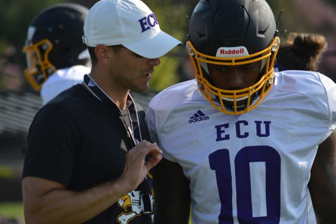 Receivers coach Drew Dudzik drills in the finer points with ECU outside receiver Leroy Henley during fall camp.