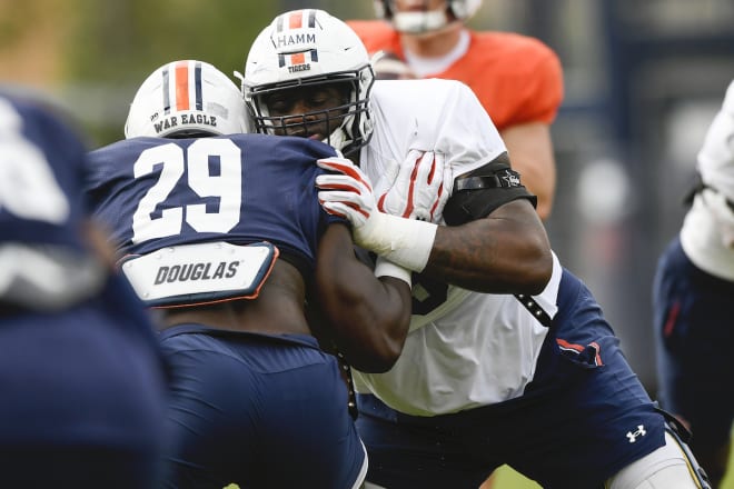 Right tackle Brodarious Hamm blocks Derick Hall in practice.