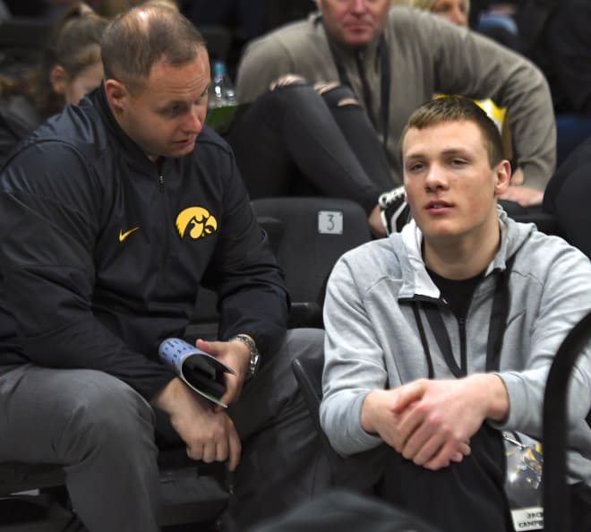 Jack Campbell talks with Iowa linebackers coach Seth Wallace at the basketball game Saturday.