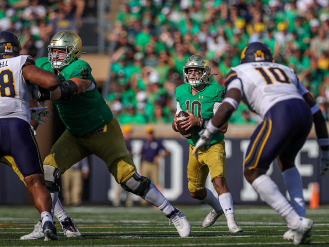 Notre Dame quarterback Drew Pyne (10 in green) drops back to pass against Cal.