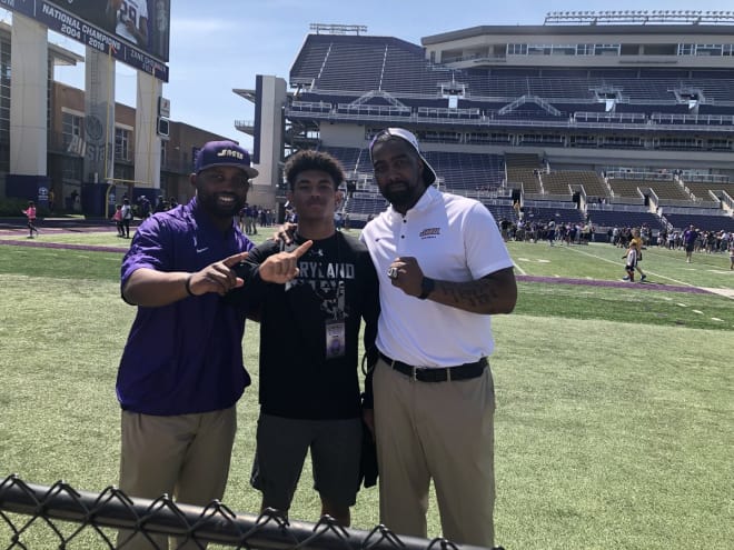 AJ Woods (middle) visits with James Madison corners coach Corico Wright (left) and inside receivers coach Fontel Mines at Bridgeforth Stadium in Harrisonburg.