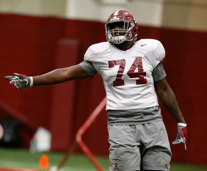 The Crimson Tide began practice for the first round of the playoffs Friday, December 16, 2016. Alabama offensive lineman Cam Robinson (74) points to a spot as a coach gives instruction.
