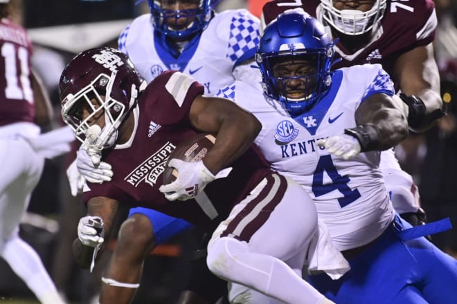 Mississippi State running back Jo'quavious Marks (7) tried to escape the grasp of Kentucky defensive end Josh Paschal.