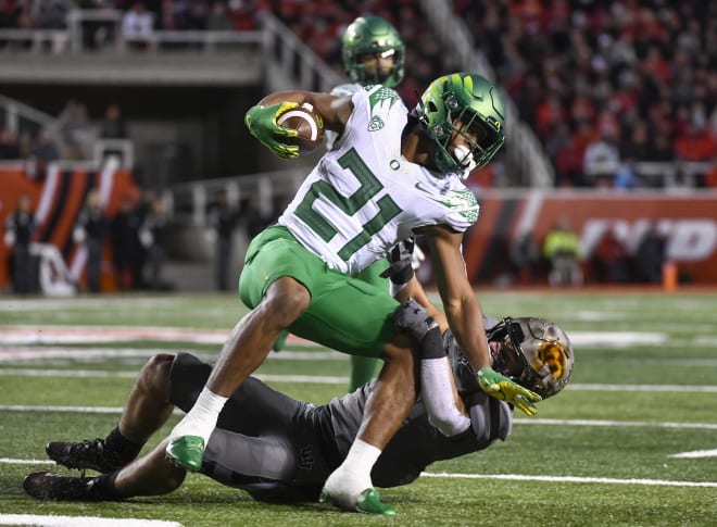Oregon's Byron Cardwell is tackled by Utah safety Cole Bishop.