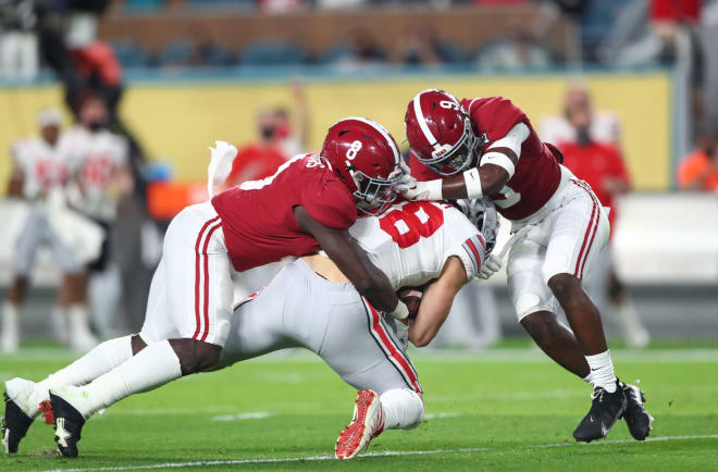 Alabama Crimson Tide linebacker Christian Harris (8) and defensive back Jordan Battle (9) tackle Ohio State Buckeyes tight end Jeremy Ruckert (88) in the 2021 College Football Playoff National Championship Game. Photo | Imagn