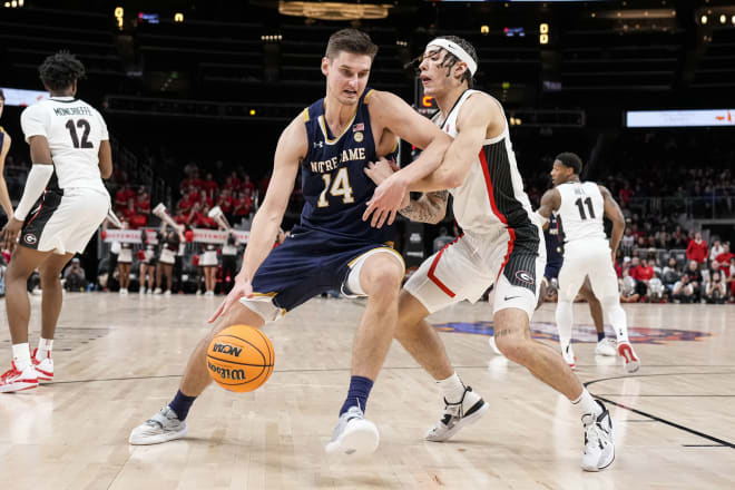 Irish forward Nate Laszewski (14) dribbles against Georgia guard Jusaun Holt (4) during ND's 77-62 loss Sunday in Atlanta.