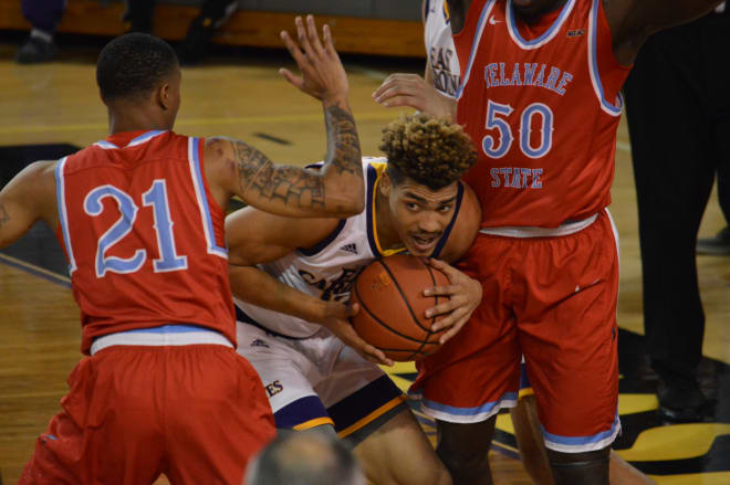 ECU's Aaron Jackson looks for room to maneuver between Delaware State's Saleick Edwards and Demola Onifade.