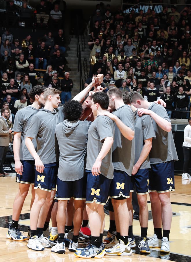 The Michigan Wolverines' basketball team huddles.