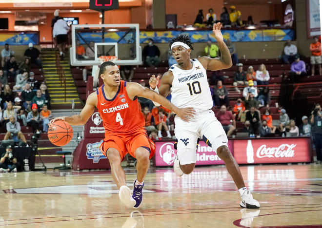 Clemson Tigers guard Nick Honor (4) dribbles past West Virginia Mountaineers guard Malik Curry (10) in the first half at TD Arena.